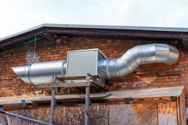 Pre-Insulated Ducting Installation - Large metallic duct system attached to a brick wall, showcasing pre-insulated ducting infrastructure